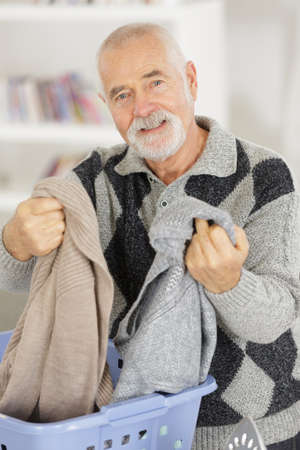 senior man doing laundry tasksの写真素材