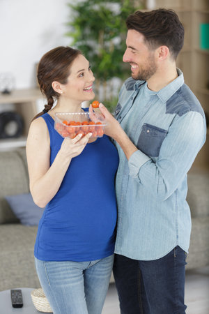 pregnant couple with tomatoes in the kitchenの写真素材