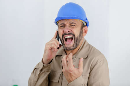 an angry builder screams on the phoneの写真素材