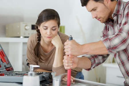 upset couple fixing kitchen sinkの写真素材