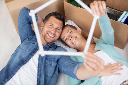 happy couple looks through a house build with a ruler