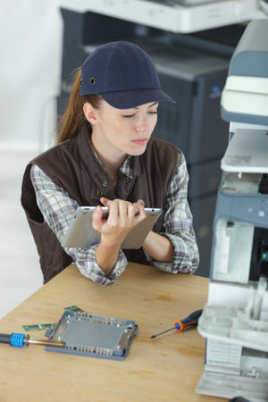 female technician repairing electronic machine