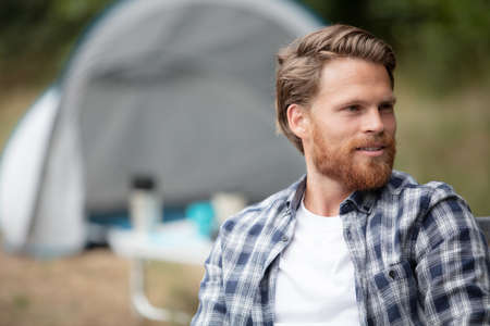 handsome cheerful man camping outdoorsの写真素材