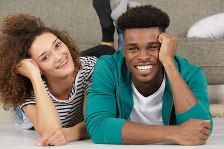 portrait of positive cheerful couple lying on floorの写真素材