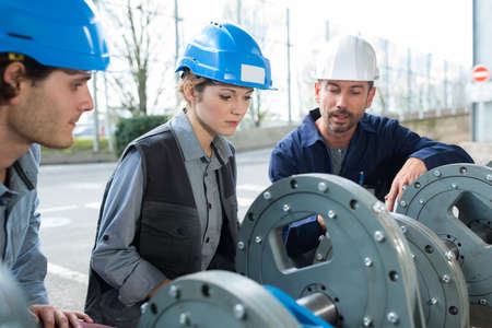 engineers working on metal dishesの写真素材