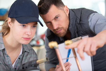 plumber teachning apprentice how to cut a copper pipe