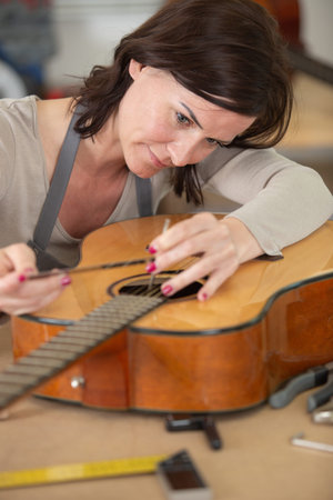 professional woman repairing guitar strings