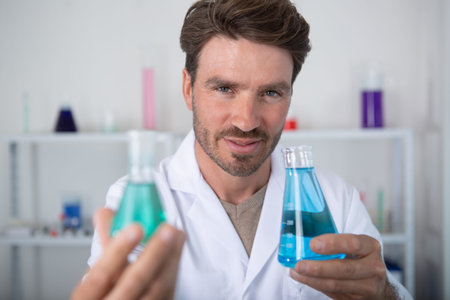 researcher holding test tube with chemist materials