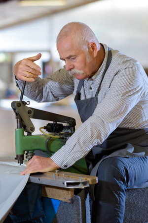 worker using industrial puncher to make hole