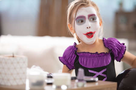 child with halloween face paint making funny expressionの写真素材