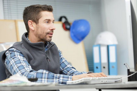 man in office wear using pc indoors