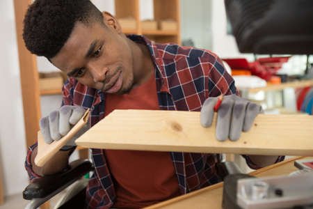 young man sanding woodの写真素材