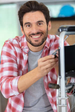 handsome young man repairing wheelchairの写真素材