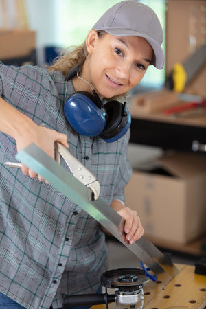 young female engineer using pliers to bend metal
