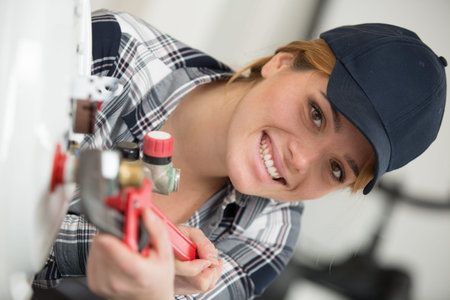happy woman fixing a boilerの写真素材