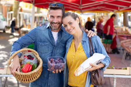 couple holding locally sourced produce bought in the marketの写真素材