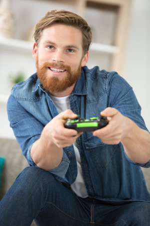 attractive young man using joystick or joypad for videogames