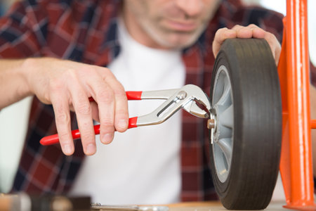 cropped image of worker fixing a trolley wheel with pliersの写真素材
