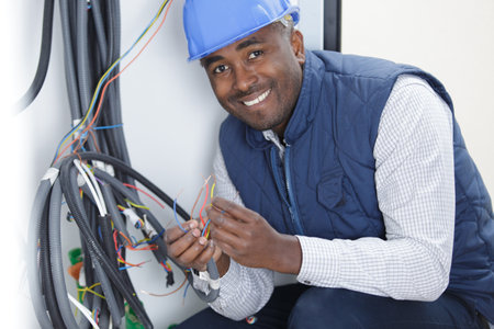 electrician working near the board with wires installation and connectionの写真素材