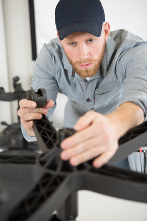 man fixing caster roller wheel of a wheel