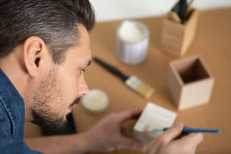 man brush painting wooden boxの写真素材