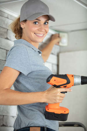 female cctv installer hinstalling security cameraの写真素材