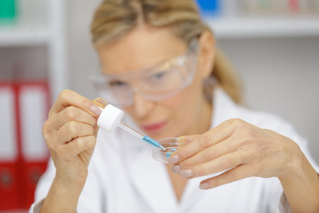 senior woman working with pipettes in a lab