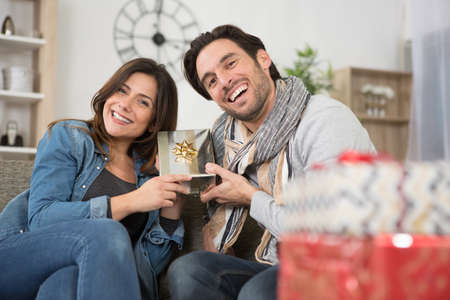 happy couple with presents at homeの写真素材