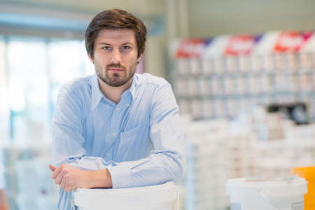 portrait of smart retailer leaning on plastic containerの写真素材