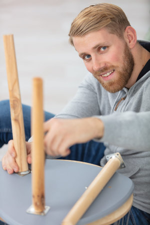 man fixing legs on to a chair