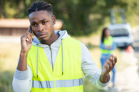man calling car towing service on a highway roadsideの写真素材