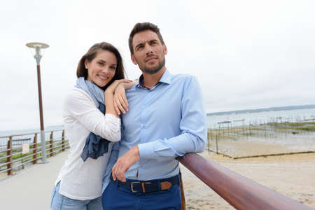 happy couple embracing on pierの写真素材