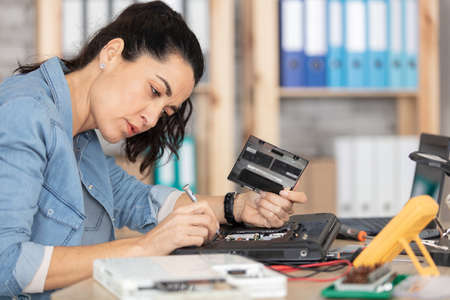 mature woman repairs a computerの写真素材