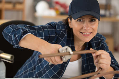 a woman cutting cooper pipesの写真素材