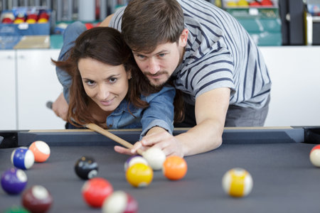 woman receiving advice on shooting pool ball while playing billiards