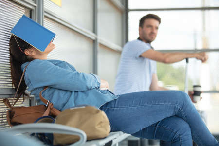 tired female traveler waiting for departureの写真素材