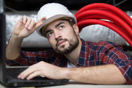 professional cctv technician working in the ceilingの写真素材