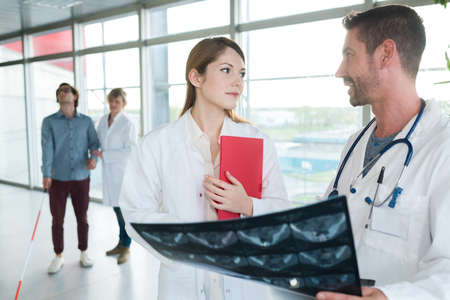 medical staff looking at xrays in hospital corridorの写真素材