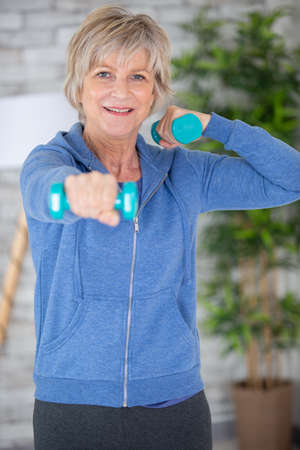 senior woman in lifting dumbell at retirement homeの写真素材