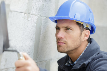 male builder working with cement block