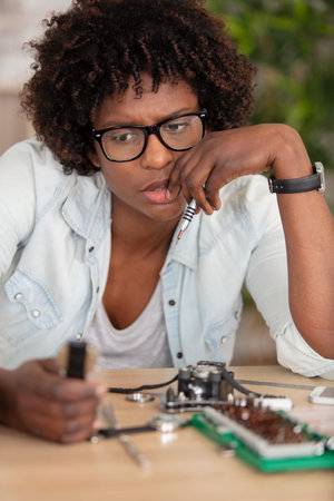 thinking female technician fixing computer a room