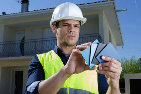 male technician checking color samples outdoorsの写真素材