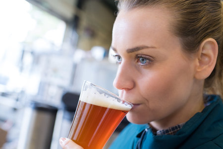 close-up of female brewer testing beerの写真素材