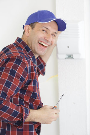 a happy worker checking thermostat
