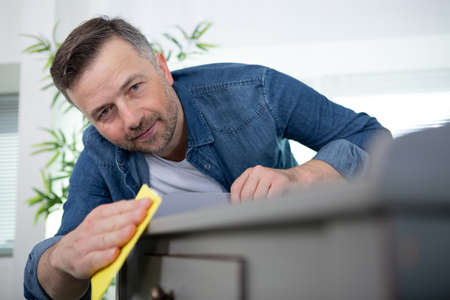 man using sandpaper to sand a wooden tableの写真素材