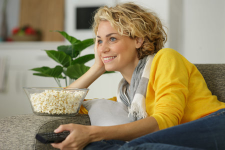 happy woman eating popcorn at home