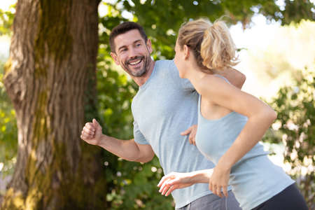 couple jogging and running outdoors in natureの写真素材