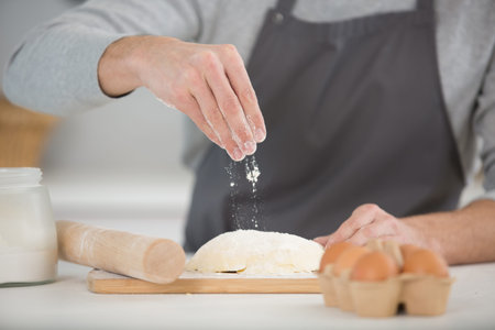 hands baking bread or pizza dough