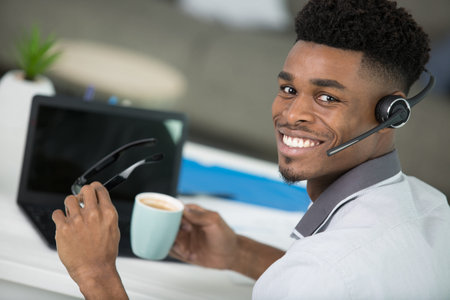 happy young man working with laptop in officeの写真素材