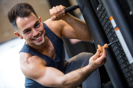 portrait of fitness man doing exercise with machine weights